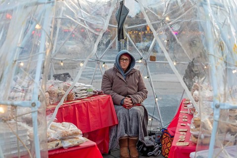 London, Ontario, Canada - A woman sells cookies and pastries on a cold day outside Covent Garden