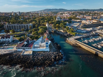 Aerial view of Santa Marta lighthouse and Cascais marina with moored yacht boats with Cascais