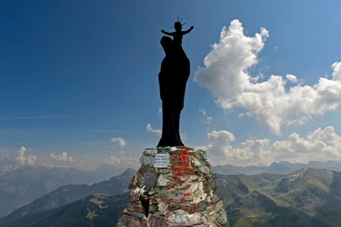 Figure of the Virgin Mary with child against the light on the summit of Mont Noble, Nax,