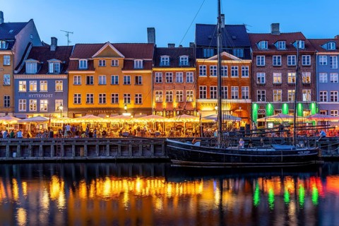 Colourful houses, restaurants and historic ships on the Nyhavn canal and harbour at dusk,