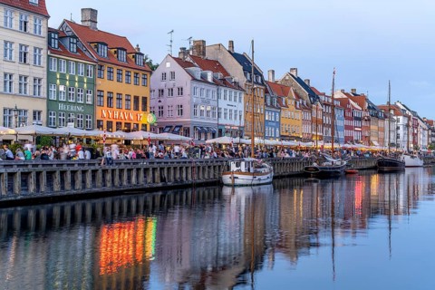 Colourful houses, restaurants and historic ships on the Nyhavn canal and harbour at dusk,