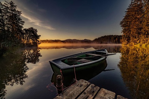 Boats in the autumnal Schmutter Weiher in the Allgäu near the municipalities of Halblech,
