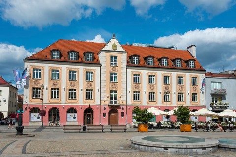 Colourful historical building on a sunny day with benches and bicycles in the foreground, bank