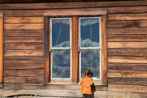 Bodie, California - A child looks in the window of the old schoolhouse at Bodie State Historic Park