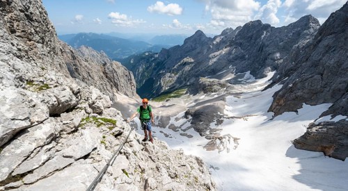 Mountaineer with helmet in a secured via ferrata, Zugspitze via ferrata, ascent to the Zugspitze,