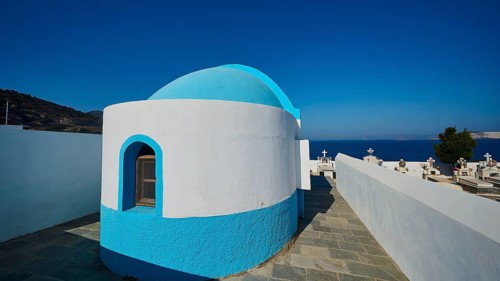 White and blue chapel next to a cemetery with sea view, Pali village, Pali, Volcanic Island,