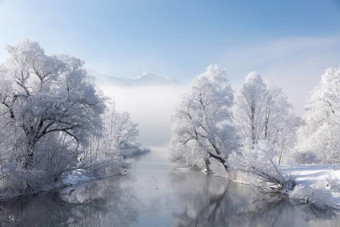 Lake Kochelsee in Bavaria, Germany. River Loisach leaving the lake. Winter, hoar frosted trees