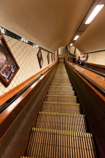 Passers-by on a wooden escalator in the Sint-Annatunnel, heritage-protected St Anne's Tunnel under