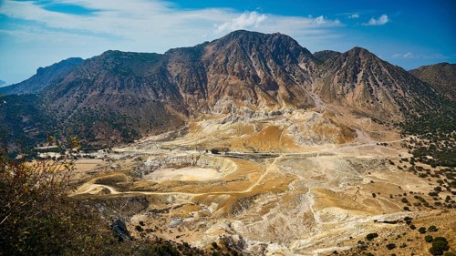 Large-scale volcanic landscape with geological diversity and majestic mountains under a wide sky,