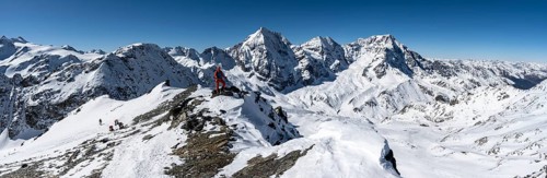 Ski tourers on foot, mountain panorama with snow-covered mountain landscape in winter, view of