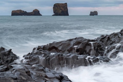 Waves, surf, washed over columnar basalt, rock needles, long exposure, Dyrhólafjara, rock gate