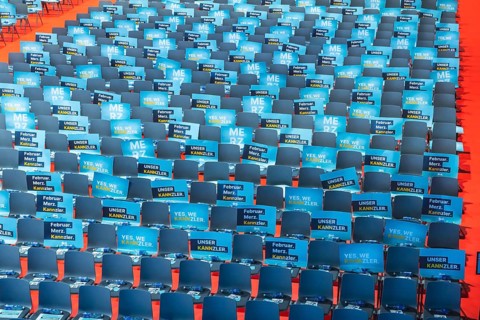 Assembly hall, deserted with many empty chairs and posters with the inscription UNSER KANNZLER.