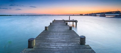 Jetty on the Peene River at sunset, behind the bascule bridge to the island of Usedom,