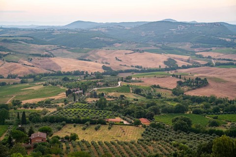 View from Montepulciano into a typical Tuscan landscape in Val d'Orcia with hills, trees, fields,