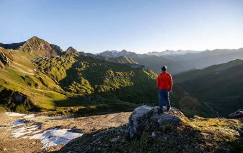 Mountaineer in front of mountain landscape at sunrise, view of mountain peaks of the Venediger