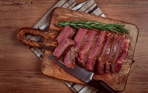 Fried steak, beef steak, rib eye steak, sliced steak, on a chopping board, top view, no people