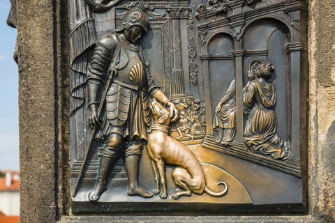 Bronze relief of a nobleman with a dog, laying hands on the relief of the dog is said to bring good