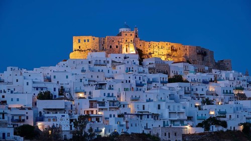 Night view of an illuminated castle above white houses with blue evening lighting, Querini Castle,
