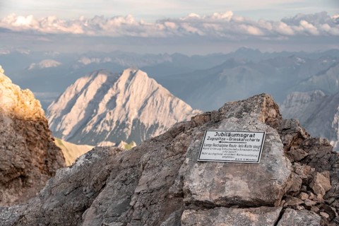 Signpost for difficult mountain tour, signpost Jubiläumsgrat in the evening light, steep rocky
