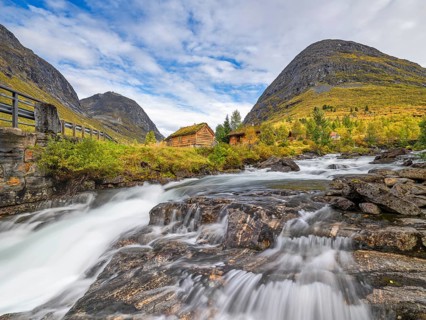 Autumn in Reinheimen National Park, cabins with green roofs, mountains with river in Valldalen