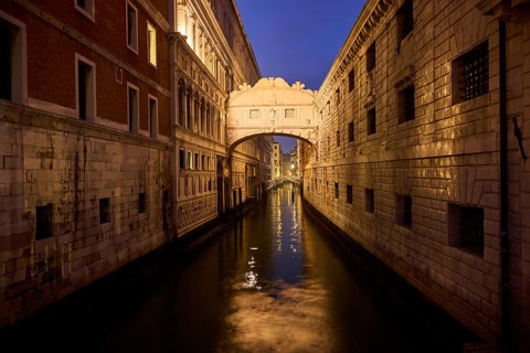 View from 'Ponte della paglia' on the bridge 'Bridge of Sighs' over a waterway at the blue hour in