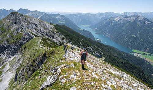 Mountaineer on the summit ridge of the Unnütz, behind Achensee and summit of the Seekarspitze