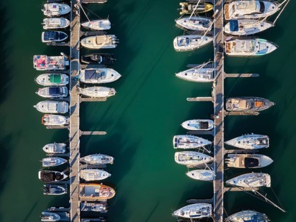 Marina with yachts aerial drone top down view. Boats and yachts moored by the pier. Cascais,