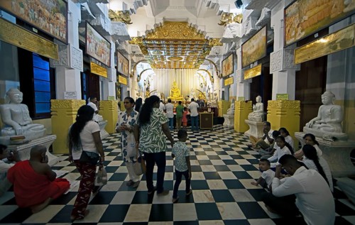 Sri Lankan pilgrims at the golden Buddha in the Buddhist Temple of the Tooth or Sri Dalada