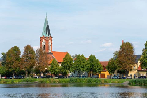 A picture of the church on the riverbank with surrounding buildings and trees, Maria Meeresstern
