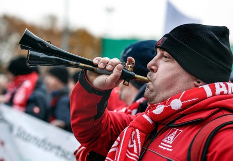 A Volkswagen employee demonstrates with a trumpet in front of the Volkswagen Arena during the