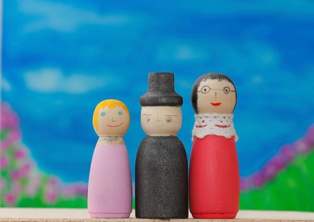 Three funny painted wooden cones in front of a painted background, North Rhine-Westphalia, Germany,