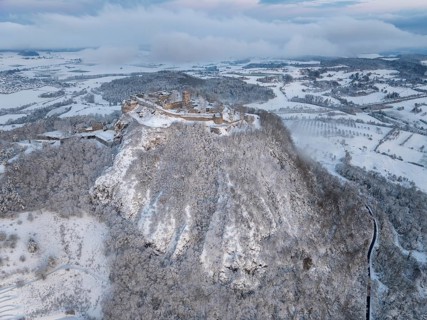 Aerial view of the snow-covered Hegau volcano Hohentwiel with Germany's largest castle ruins on a