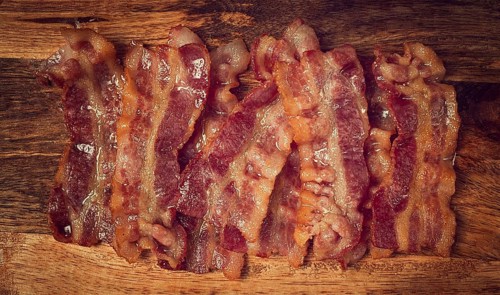 Fried bacon on a cutting board, top view, close-up, homemade, breakfast, no people