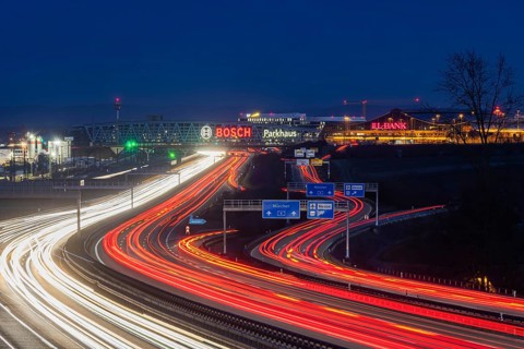 A8 motorway at Stuttgart Airport in the evening. Heavy traffic, lanes of light. Modern architecture