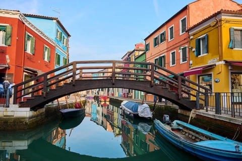 Colorful houses and a bridge 'Love viewing bridge' going over the waterway with boats lying in the