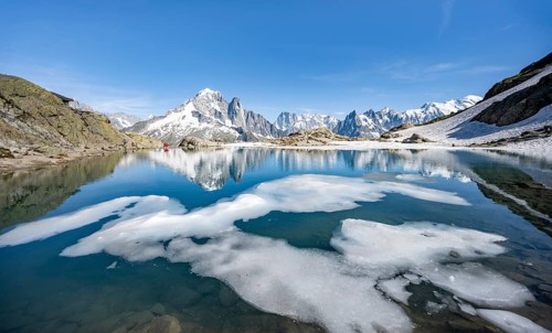 Mountain landscape with mountain lake and ice floe, water reflection in Lac Blanc, mountain peak,