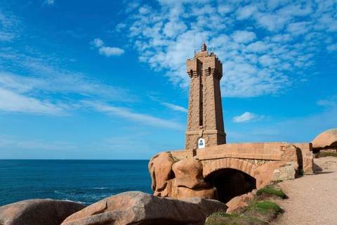 A lighthouse stands over a bridge on the rocky coast, Phare de Men Ruz, Ploumanac'h, Ploumanach,