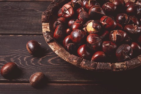 Roasted chestnuts, in a wooden plate, top view, homemade, no people