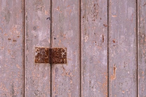 Old wooden door with peeling paint and metal fittings, texture, background, Apulia, Italy, Europe