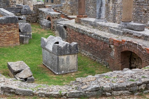 High angle view of old semi circle grey stone structure, terracotta brick wall and columns at