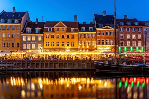 Colourful houses, restaurants and historic ships on the Nyhavn canal and harbour at dusk,