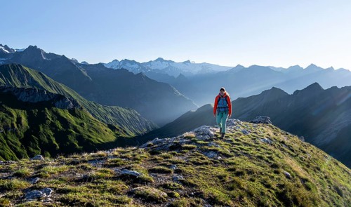 Hiker enjoying the mountain panorama in the morning, Venediger group, behind Dreiherrenkopf,