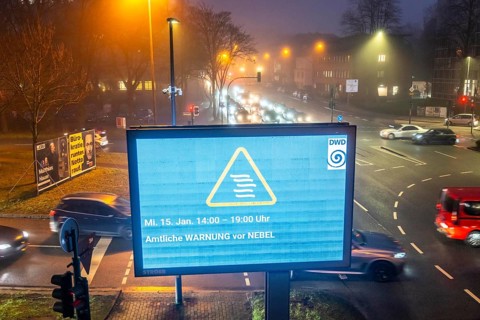 Dense fog, with visibility partly below 100 metres, city centre traffic at rush hour on