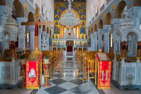 Magnificently decorated church interior with icons, red velvet and golden decoration in the nave,