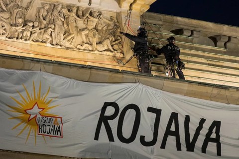 Police officers from the High Altitude Rescue Team remove a banner with the inscription For
