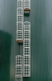 Fixed ladders with back protection on a technical building, climbing protection, silo, offset