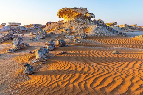 Striking cliffs surrounded by windswept sand structures, Huqf stone desert, Arabian Peninsula,