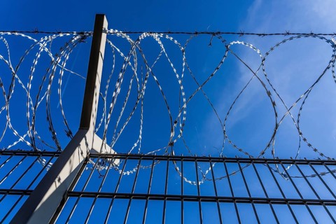 Symbolic image security, S-wire rolls, NATO wire, on a fence top, demarcation of a property,