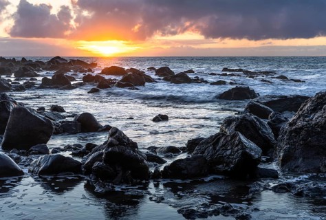 Rocks on the beach of Playa del Inglés. Sunset. Sea and waves. Valle Gran Rey, La Gomera, Canary