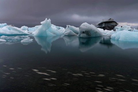 Icebergs under dark clouds, dramatic and threatening, long exposure, glacier lagoon Jökulsárlón or